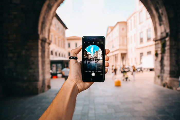 Person holding an iPhone and taking a photo 