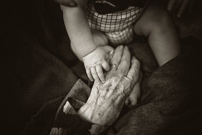 Celebrating age is a growing photography trend: A baby's hand touching an old person hands