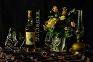 Still life photography shot of whisky and flowers on a tabletop