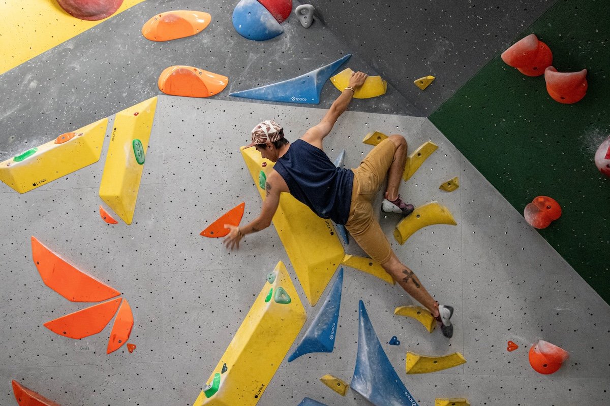 A sharp picture of an indoor rock climber scaling a wall