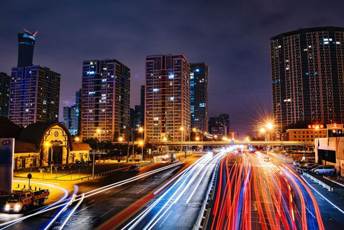 A busy night cityscape with streaming light trails