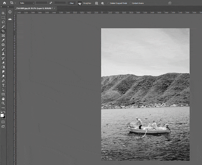 Video screenshot of Photoshop workspace showing how to straighten the horizon line using the Crop tool.