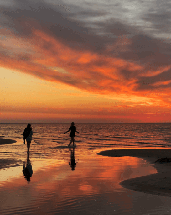 sunset beach photo with two people's silhouettes taken with an iphone