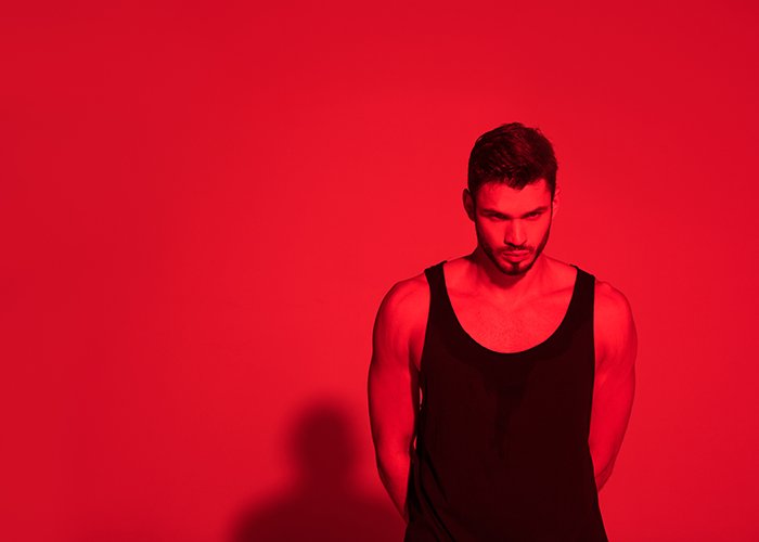 Young man under contrasty red light.