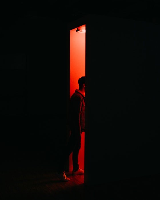 A man walking into a photography darkroom
