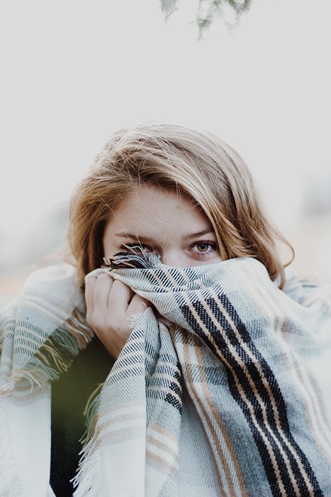 Girl hiding her face in a scarf