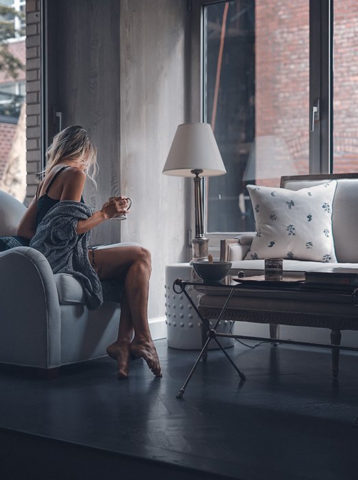 Blonde girl drinking coffee in a living room