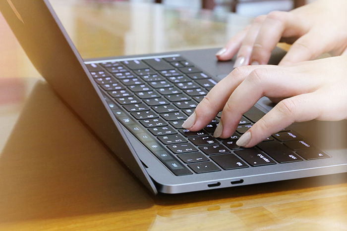 Typing on laptop keyboard.