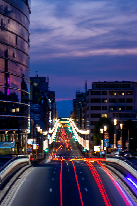 Cityscape with lightrails on a busy motorway right before nightfall. 