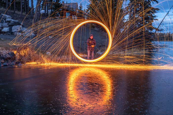 Steel wool photography with a man stanting in the middle of the circle
