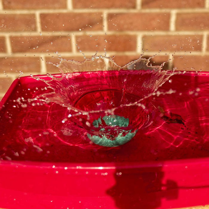 An object dropped in a dish creating a splash for high-speed photography