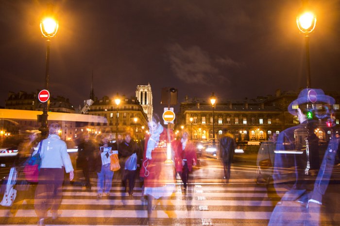 People crossing the zebra at night. They are blurred. 