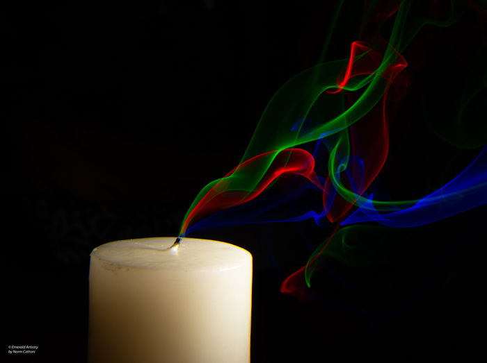 Photo of a candle with colorful smoke