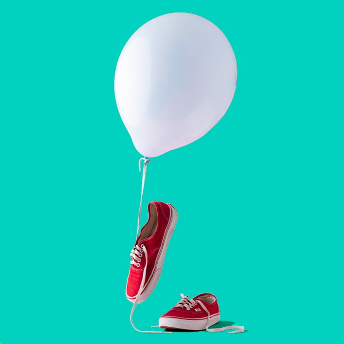 photo of red sneakers with a white balloon and a turquoise background