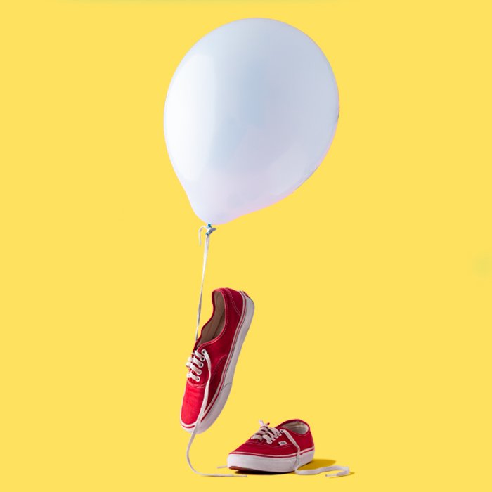 photo of red sneakers with a white balloon and yellow background
