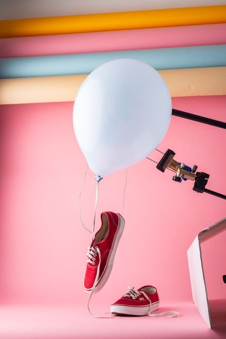 photo of red sneakers with a white balloon and pink background