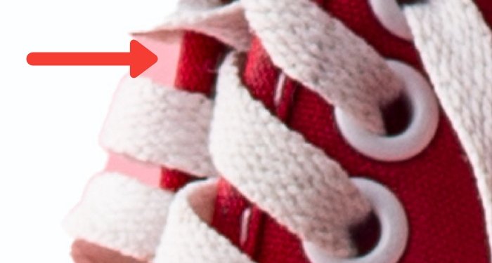 close-up photo of the shoelaces of a pair of red sneakers