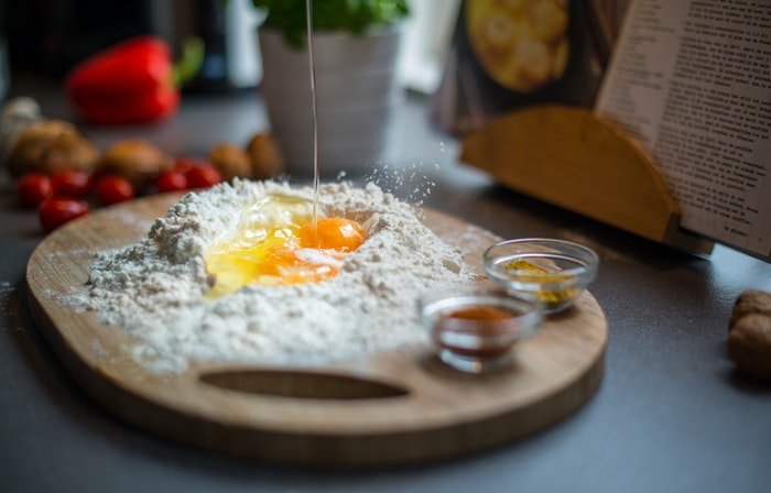Eggs and flour on a wooden chopping board
