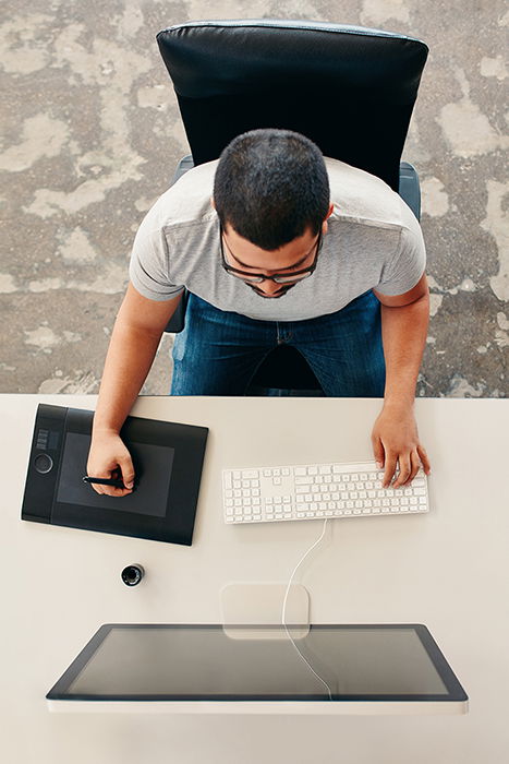 Photographer uses his desktop computer for photo editing.