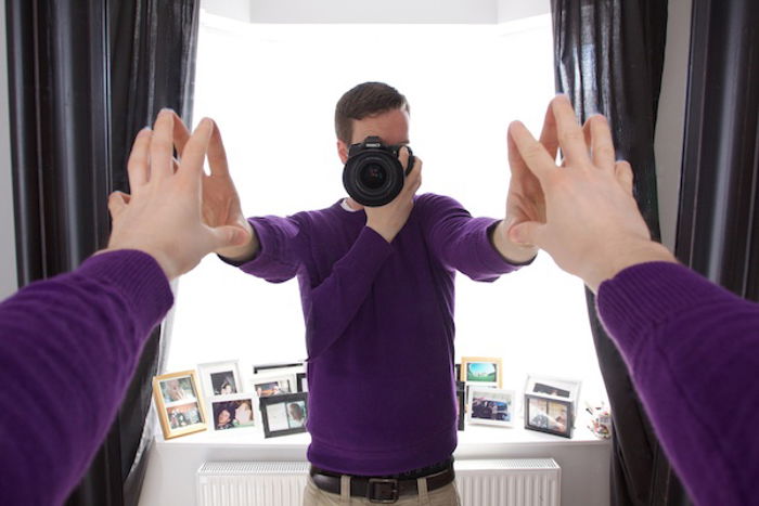 photo of a man taking a photo of himself in the mirror