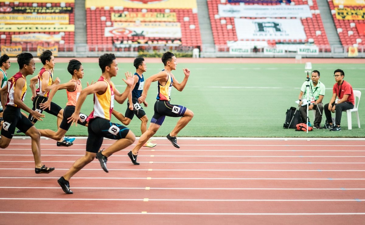 Sprinters on a track and field course running to the finish line for high-speed photography
