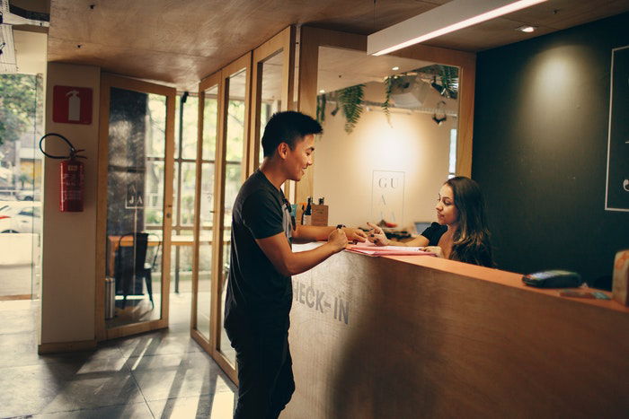 A man checking in at a hotel reception 