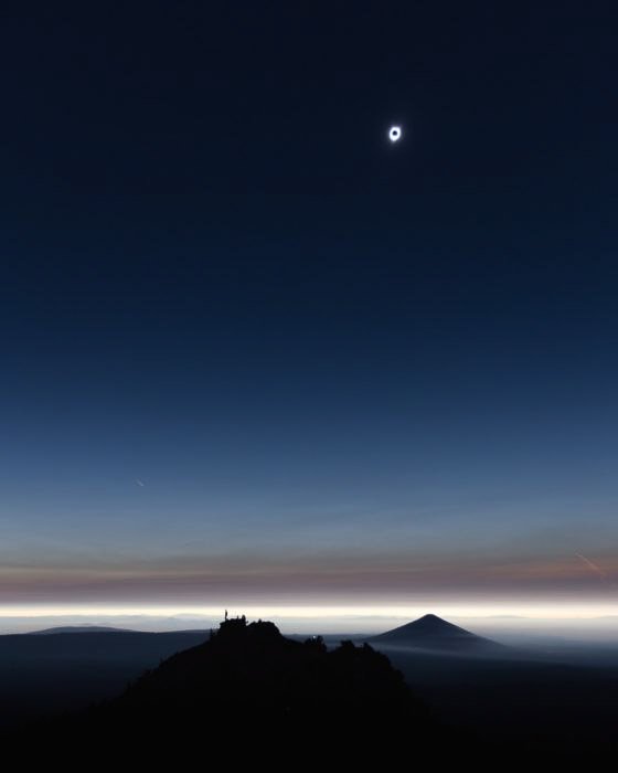photo of the solar eclipse over a landscape at night
