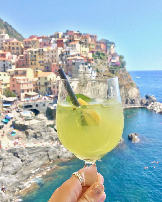 Un limoncello spritz frente a un hermoso pueblo costero