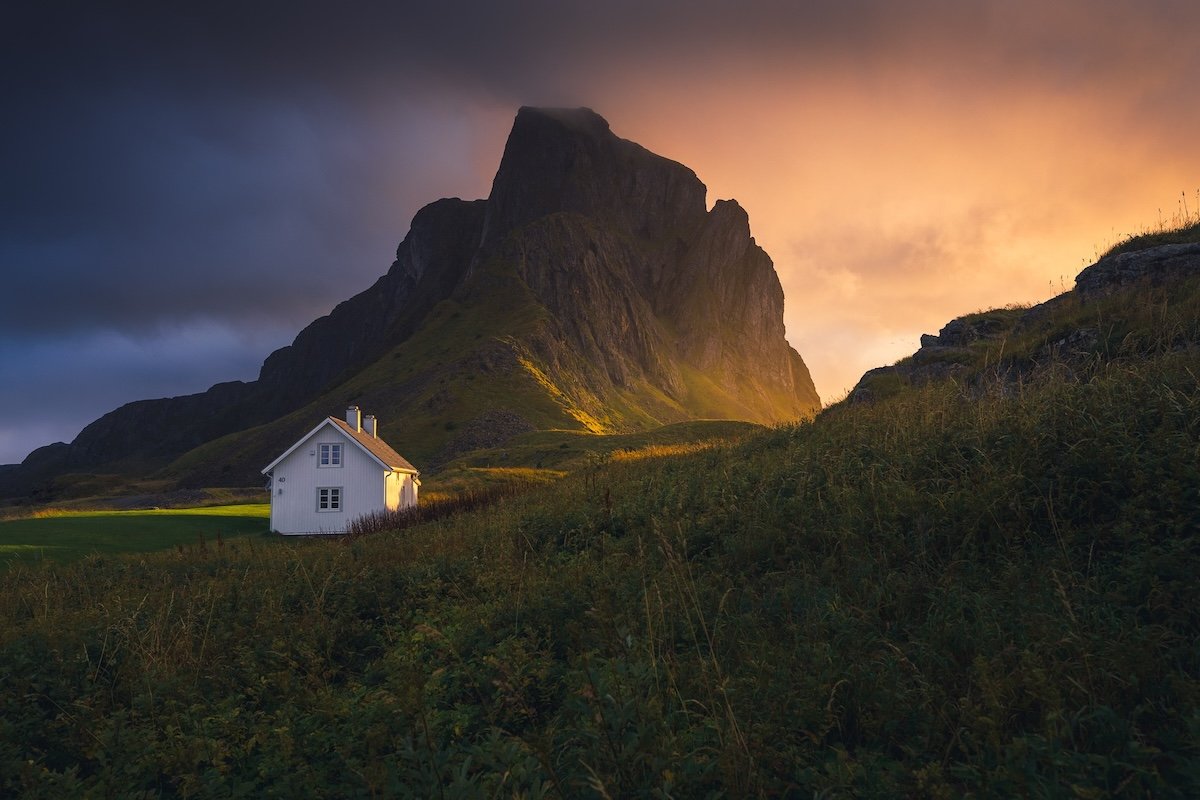 A Norway cabin in front of a mountain at dusk by one of the best nature photographers Marco Grassi