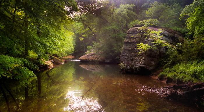 Photo of a small lake in a forest with orton effect