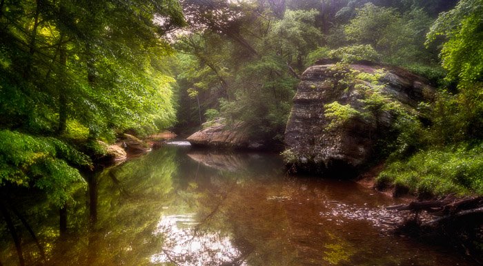 Photo of a small lake in a forest with orton effect