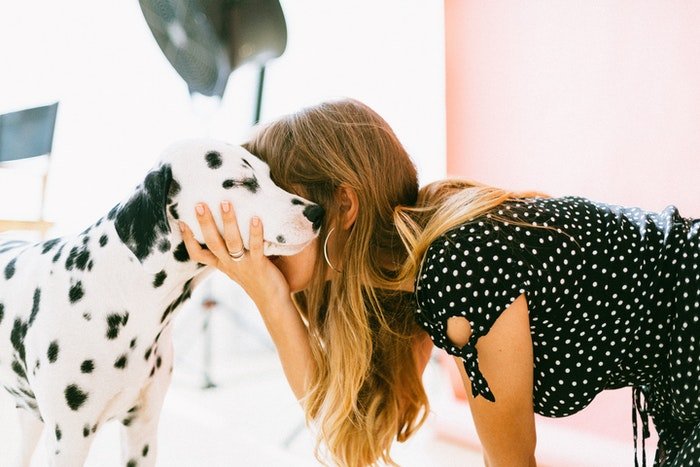 A girl embracing a dalmatian dog