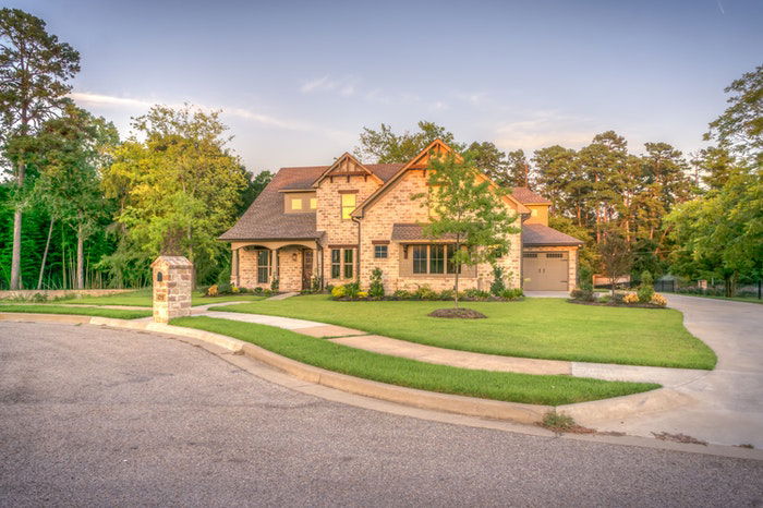 photo of a rustic style house with a green lawn