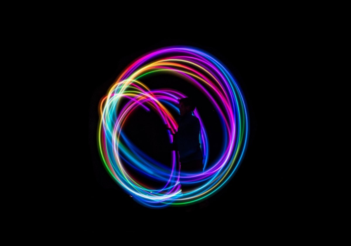 Colorful circular light graffiti against a black background as a creative photography challenge