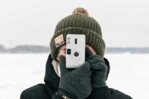 Person holding up an instant camera to take a picture for a photography challenge