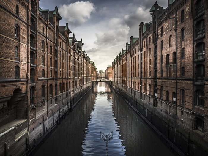 photo of a canal with brick buildings on both sides