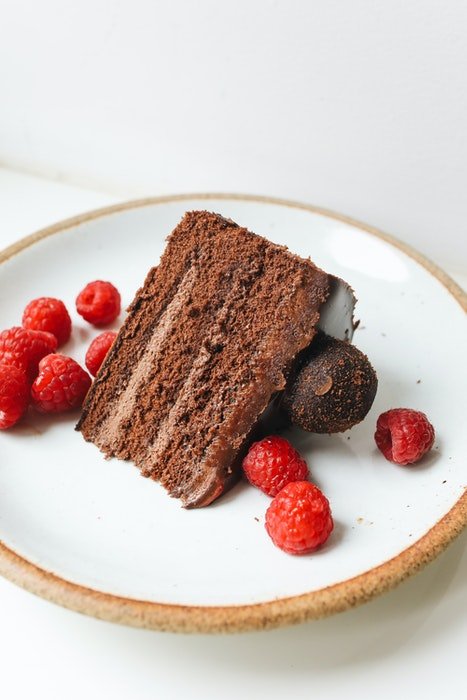 High angle photo of a delicious chocolate cake on a plate with berries