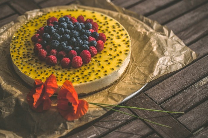 Cake photography of a fruity cheese cake on a rustic table