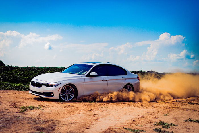 Photo of a driving car on a dirt road