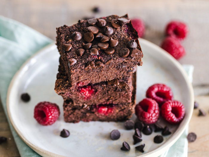 Chocolate brownies piled on a white plate