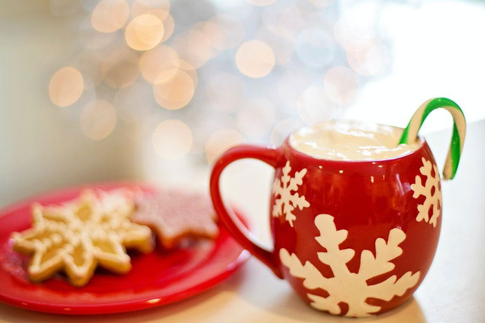 A christmas drink beside a plate of cookies