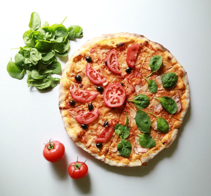 Flat lay food photo of a pizza plus extra ingredients