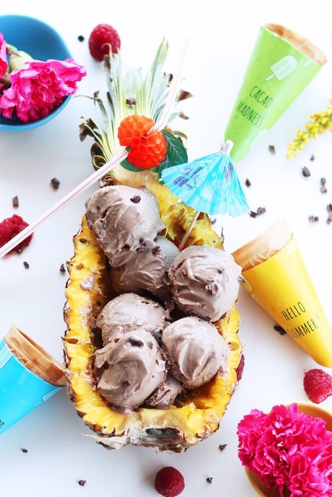 Flat lay photo of fruity ice cream served in a pineapple and ingredients