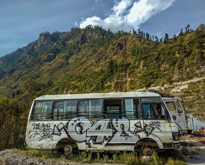 Juxtaposition of a van with graffiti against the beauty of nature 