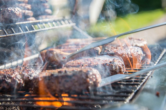 A row of burgers on a barbeque