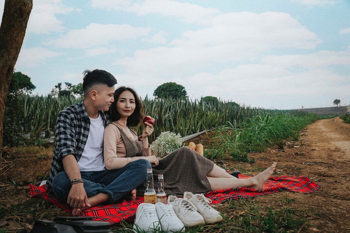 A couple having a picnic photoshoot under a tree