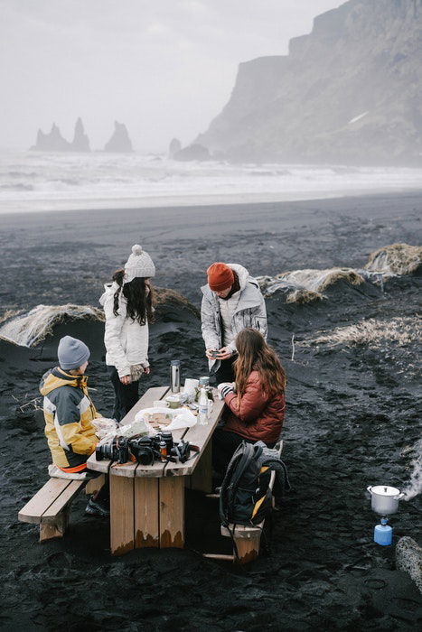 A family having a picnic on a rocky misty beach