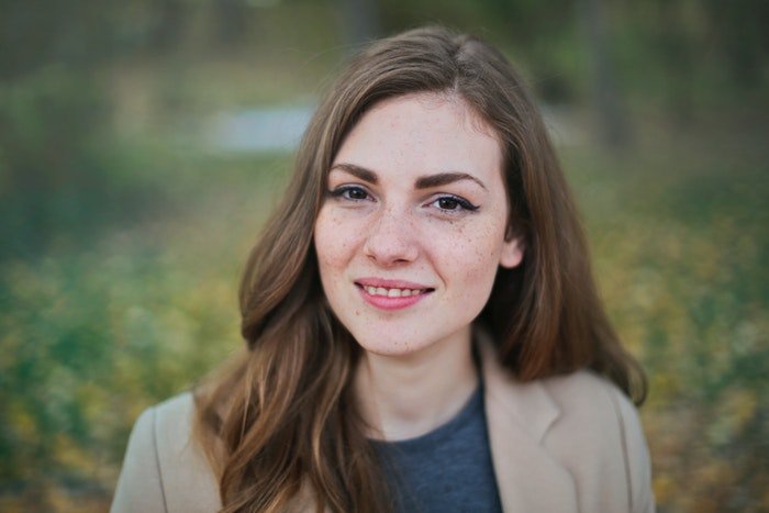 Outdoor headshot photo of a young woman