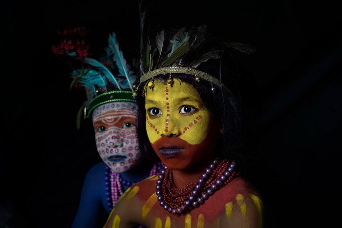 Portrait of two indigenous boys in colorful makeup and traditional clothing