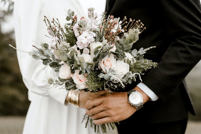 A wedding portrait closeup of the newlyweds embracing outdoors